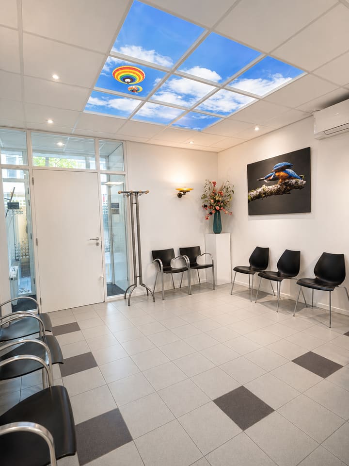 Wachtruimte met wolkenplafond bij Dental Care Glashaven
