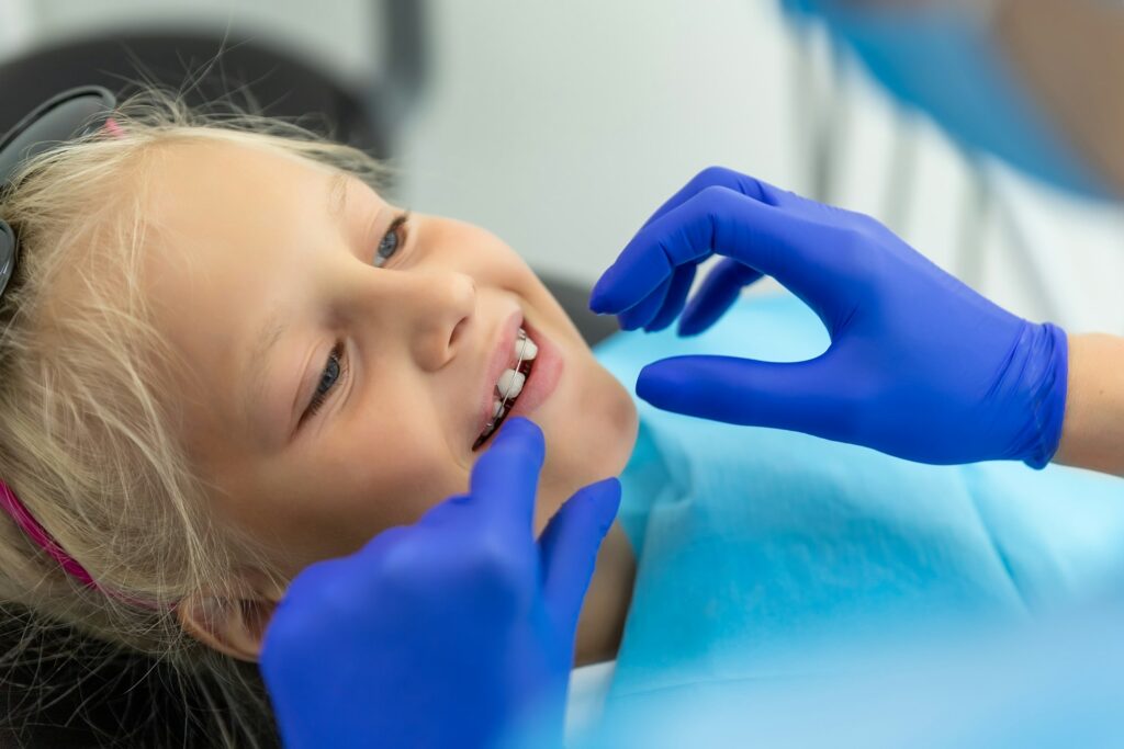 Little cute adorable happy caucasian blond kid girl at dentist office at dentist check-up of dental